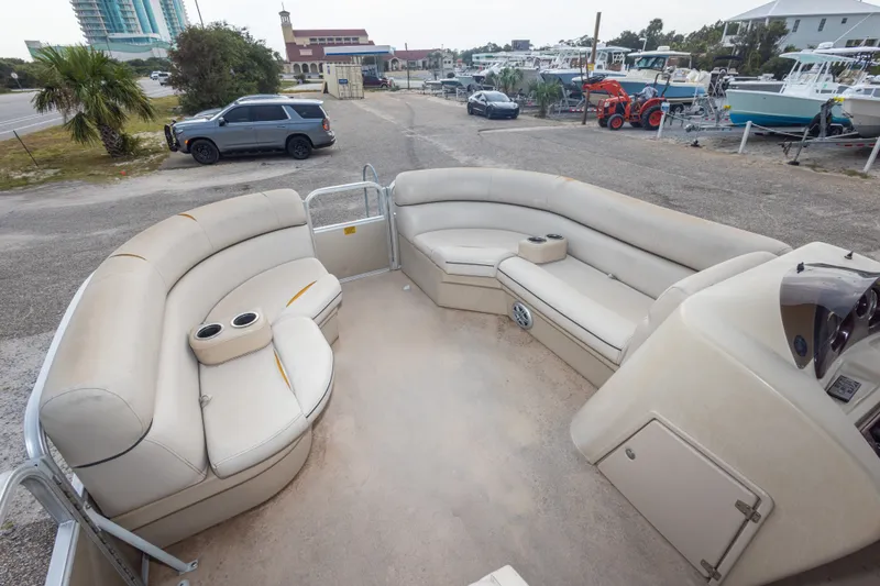 Slide: The Image of 2016 South Bay 5220CR pontoon boat with spacious seating and cup holders, parked outdoors. - 30