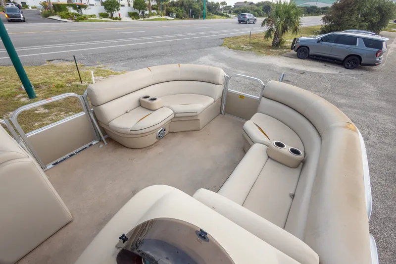 Slide: The Image of 2016 South Bay 5220CR pontoon boat with spacious seating and cup holders, parked near a road. - 27