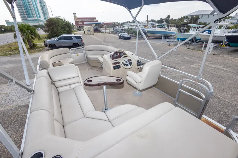 Slide: The Image of 2016 South Bay 5220CR pontoon boat with spacious seating and steering console, parked near marina. - 33