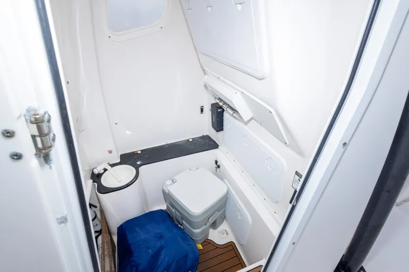 Slide: The Image of Interior of 2016 Sea Fox 288 Commander boat's compact bathroom with toilet and storage. - 32