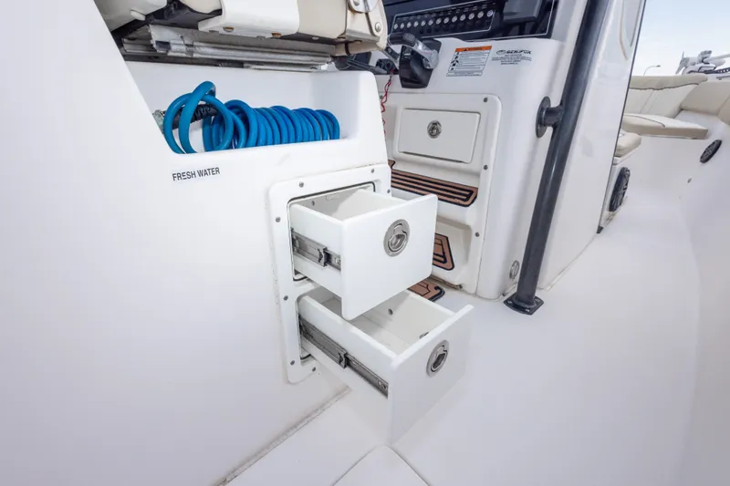 Slide: The Image of 2016 Sea Fox 288 Commander boat interior with storage drawers and fresh water hose. - 57
