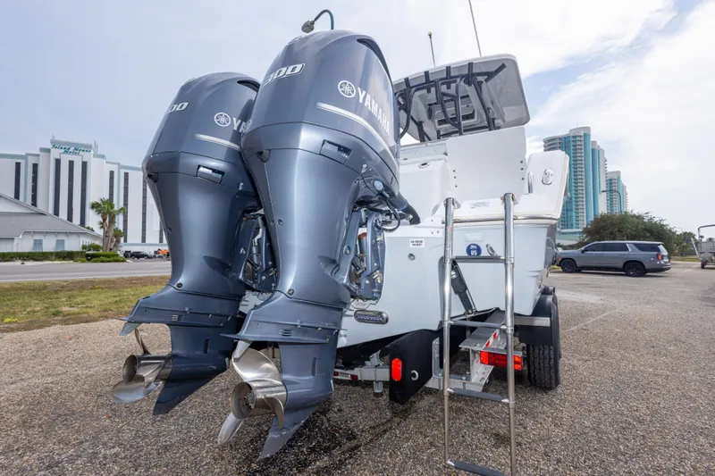 Slide: The Image of 2016 Sea Fox 288 Commander with twin Yamaha outboard engines, parked near modern buildings. - 58