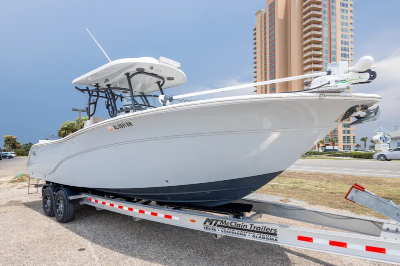 Slide: The Image of 2016 Sea Fox 288 Commander boat on trailer, parked near a tall building. - 11