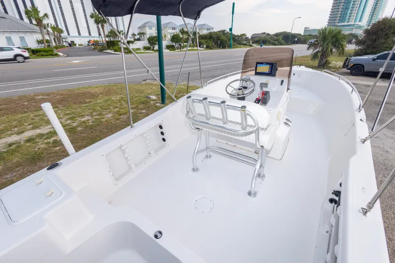 Slide: The Image of 2011 PROLINE 21 CC SE boat with center console and seating, parked near a road. - 37
