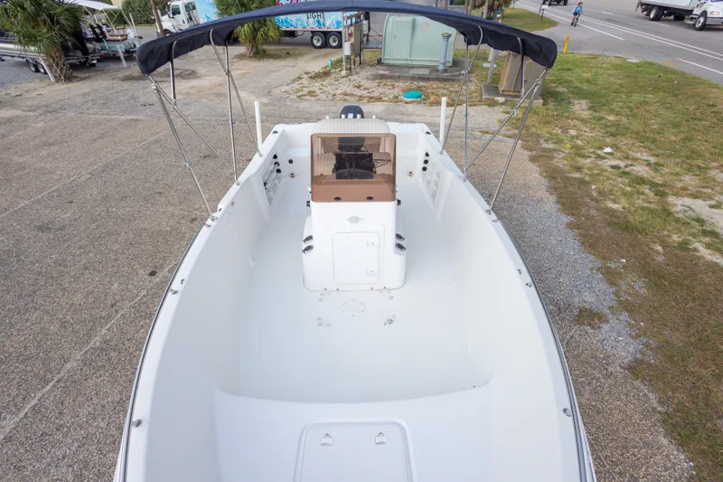 Slide: The Image of 2011 PROLINE 21 CC SE boat with canopy, parked on gravel near road. - 27