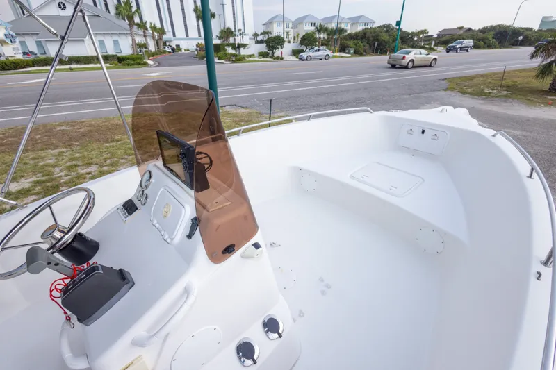 Slide: The Image of 2011 PROLINE 21 CC SE boat interior with steering console and windshield, parked near a road. - 29