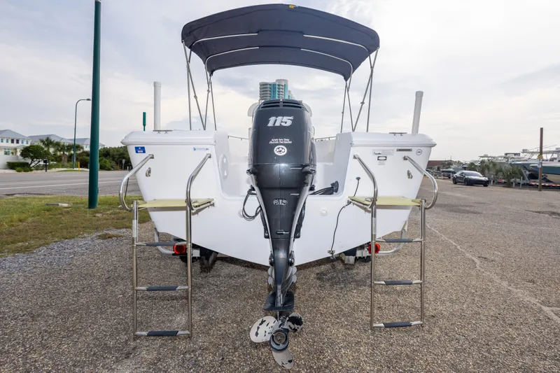 Slide: The Image of 2011 PROLINE 21 CC SE boat with outboard motor and dual ladders, parked on gravel. - 41