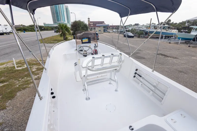 Slide: The Image of 2011 PROLINE 21 CC SE boat interior with steering console and seating, parked near a road. - 36
