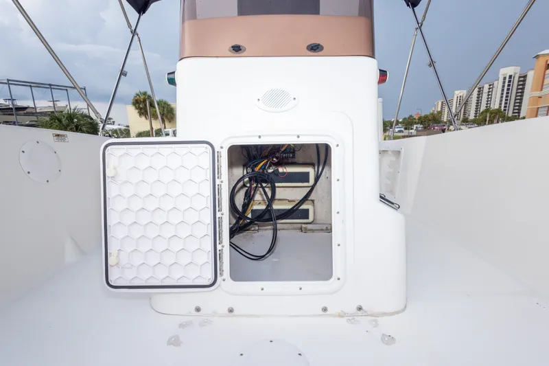 Slide: The Image of 2011 PROLINE 21 CC SE boat with open storage compartment, showing wiring and equipment. - 24