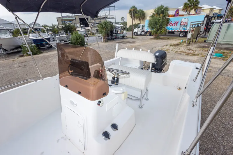 Slide: The Image of 2011 PROLINE 21 CC SE boat interior with console, seating, and outboard motor in marina setting. - 22
