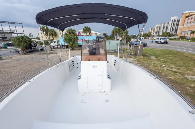 Slide: The Image of 2011 PROLINE 21 CC SE boat with canopy, parked near a road and buildings. - 26
