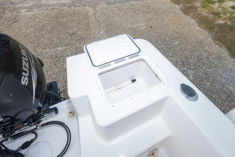 Slide: The Image of 2011 PROLINE 21 CC SE boat with open storage compartment and Suzuki engine. - 16