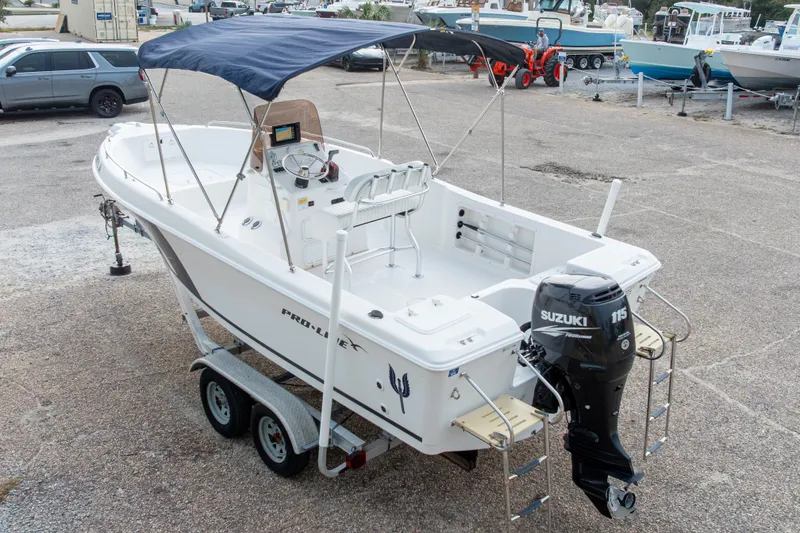 Slide: The Image of 2011 PROLINE 21 CC SE boat with Suzuki 115 engine on trailer, parked outdoors. - 44