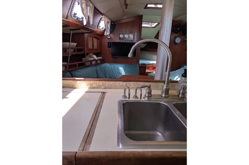 Slide: The Image of Interior of 1988 Ericson 38-200 sailboat, featuring a kitchen sink and cozy seating area. - 36