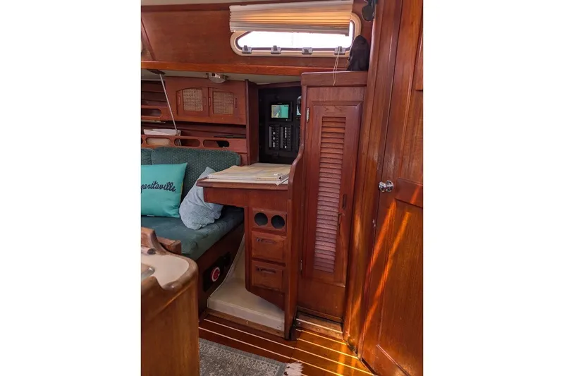 Slide: The Image of Interior of 1988 Ericson 38-200 sailboat with wooden cabinetry and cozy seating area. - 38