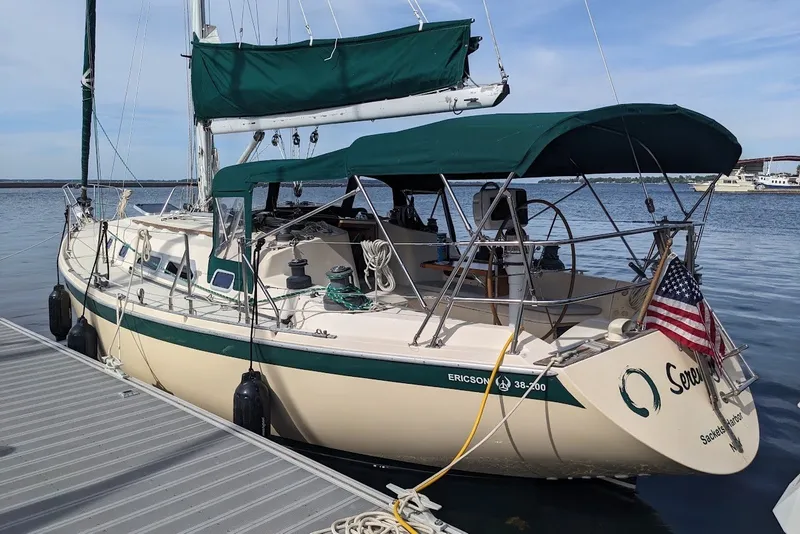 The Image of 1988 Ericson 38-200 sailboat docked, featuring green canopy and American flag. - 10