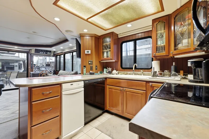 Slide: The Image of Luxurious kitchen interior of a 2002 Monticello 16x70 houseboat with wooden cabinetry and modern appliances. - 33