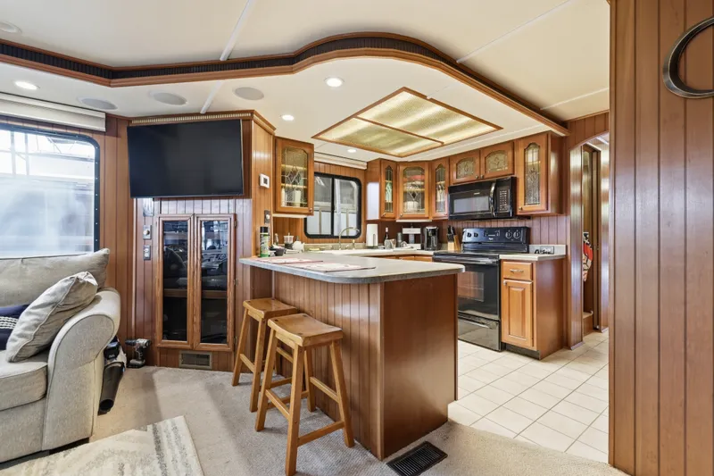 Slide: The Image of Luxurious 2002 Monticello 16x70 houseboat kitchen with wood cabinetry and modern appliances. - 32