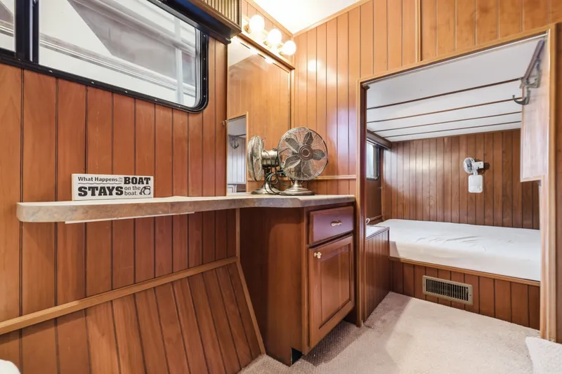 Slide: The Image of Cozy 2002 Monticello 16x70 boat interior with wood paneling and vintage decor. - 52