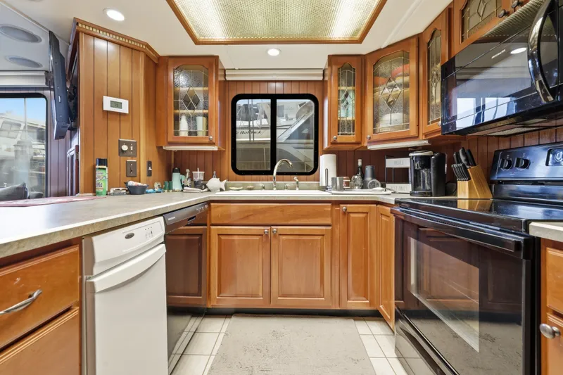 Slide: The Image of Luxurious kitchen in a 2002 Monticello 16x70 houseboat with wooden cabinets and modern appliances. - 34