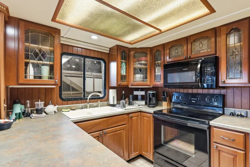 Slide: The Image of Kitchen interior of 2002 Monticello 16x70 with wooden cabinets and modern appliances. - 35