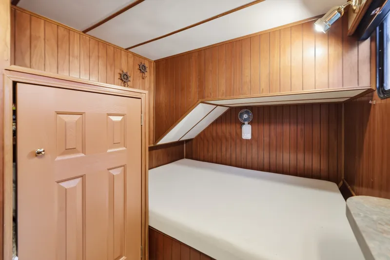 Slide: The Image of Wood-paneled cabin interior with bed, small fan, and light in Monticello 16x70, 2002 model. - 51