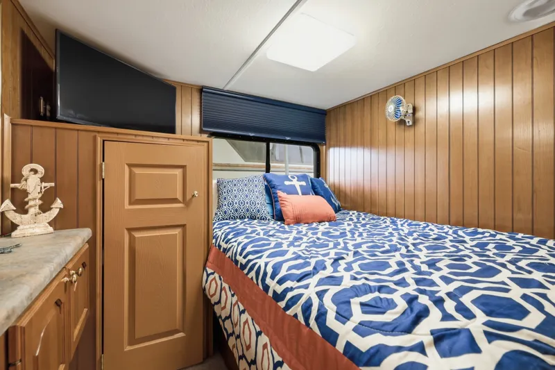 Slide: The Image of Cozy bedroom in 2002 Monticello 16x70 houseboat with nautical-themed bedding and wood paneling. - 40