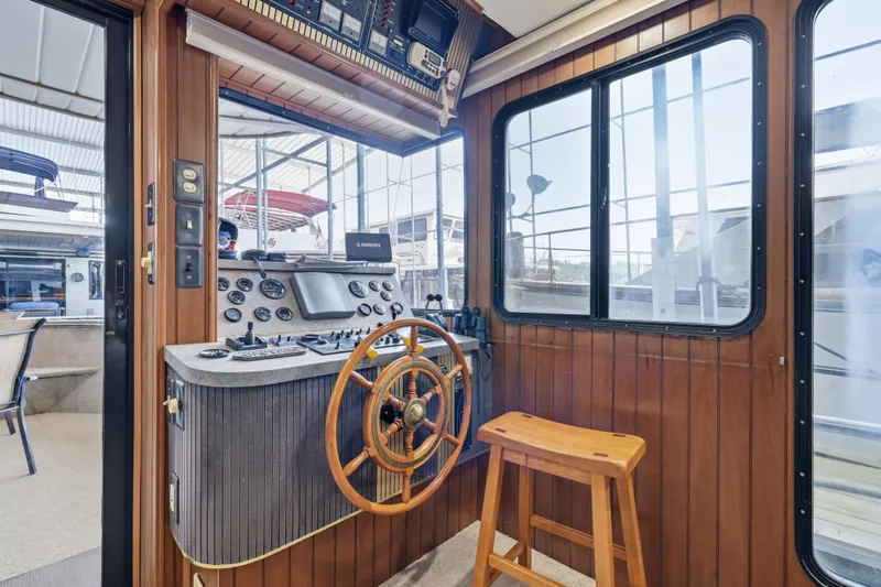 Slide: The Image of 2002 Monticello 16x70 houseboat helm with wooden steering wheel and control panel. - 28