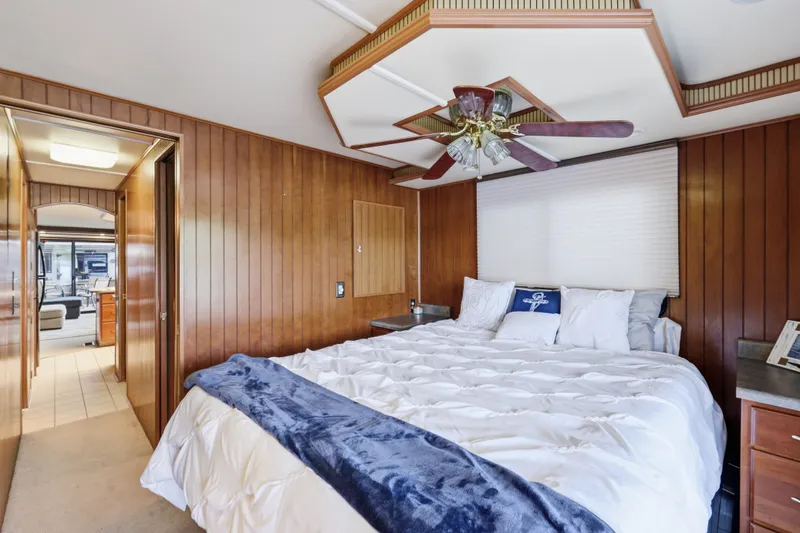 Slide: The Image of Luxurious bedroom in 2002 Monticello 16x70 houseboat with wood paneling and ceiling fan. - 59