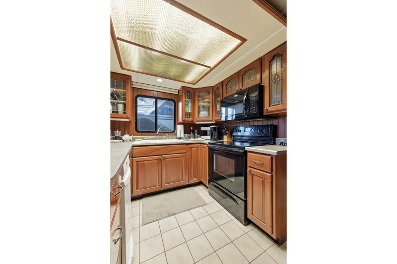 Slide: The Image of Luxurious kitchen in 2002 Monticello 16x70 houseboat with wooden cabinets and modern appliances. - 37