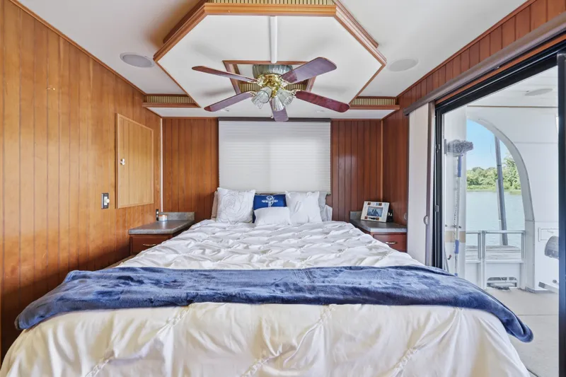 Slide: The Image of Luxurious bedroom in 2002 Monticello 16x70 houseboat with wood paneling and lake view. - 57
