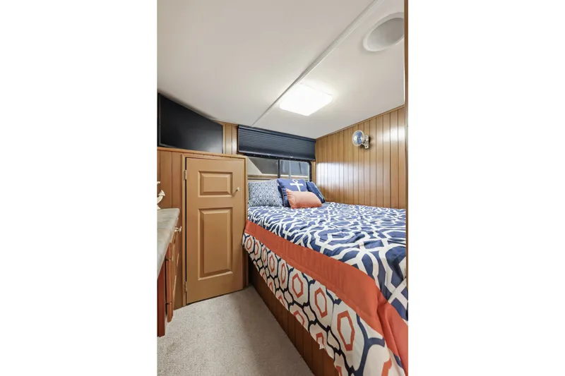 Slide: The Image of Cozy bedroom in 2002 Monticello 16x70 houseboat with patterned bedding and wood paneling. - 42
