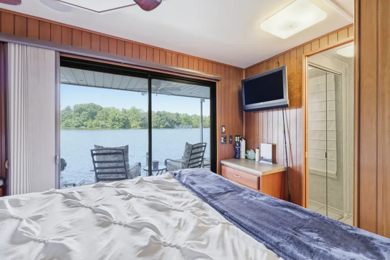 Slide: The Image of Bedroom view in 2002 Monticello 16x70 houseboat, featuring lake scenery and cozy interior. - 58