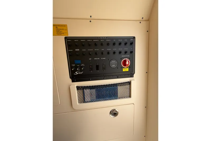 Slide: The Image of Control panel of a 2020 Scout 235 XSF boat, featuring switches and storage compartment. - 17
