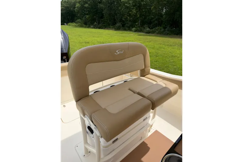 Slide: The Image of 2020 Scout 235 XSF boat seat with tan upholstery, set against a grassy background. - 15