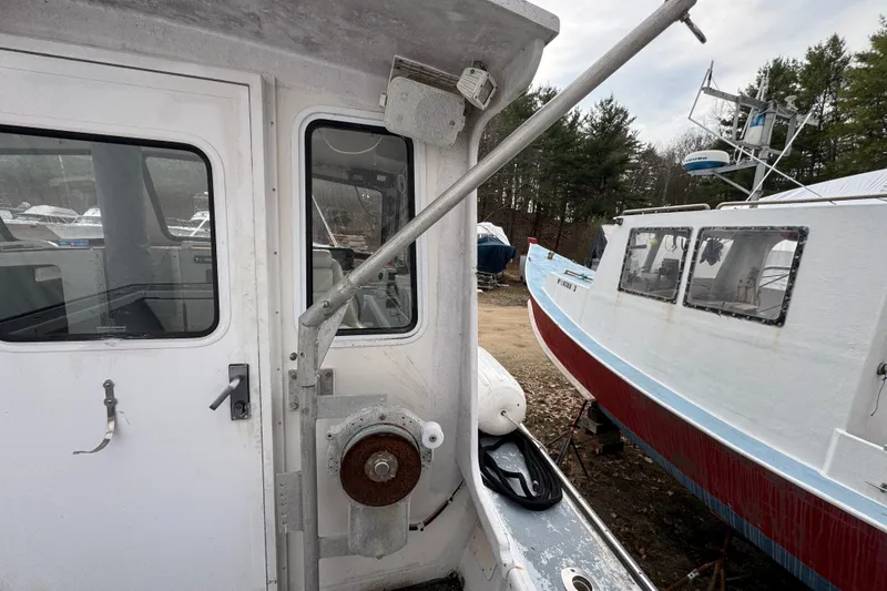 Slide: The Image of 2007 Northern Bay 36 boat docked, showing cabin door and nearby vessel. - 15