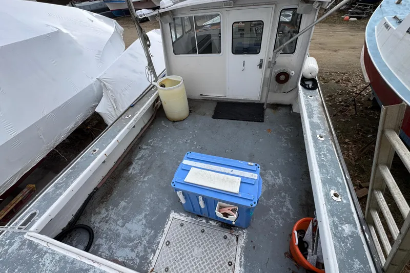 Slide: The Image of 2007 Northern Bay 36 boat deck with blue cooler and white cabin entrance. - 11