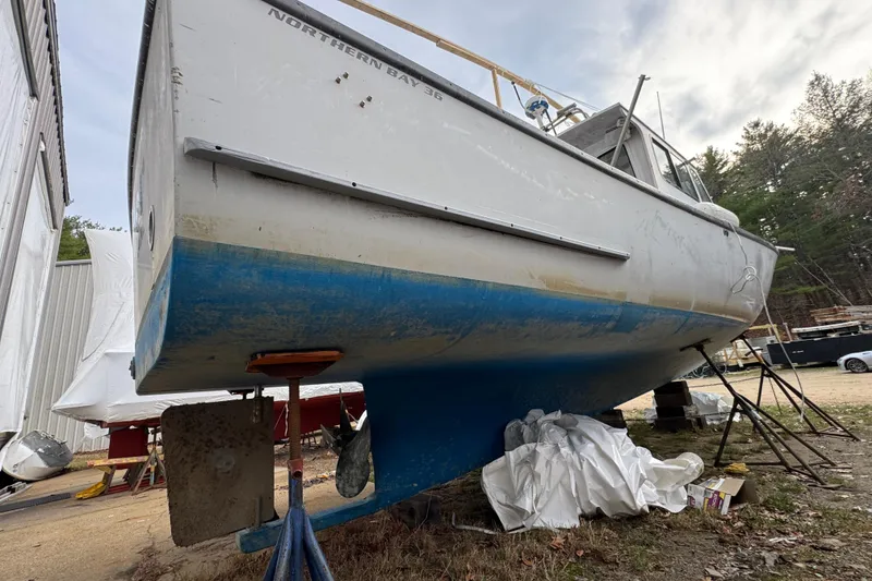 Slide: The Image of 2007 Northern Bay 36 boat on dry dock, showing hull and rudder, surrounded by trees. - 7