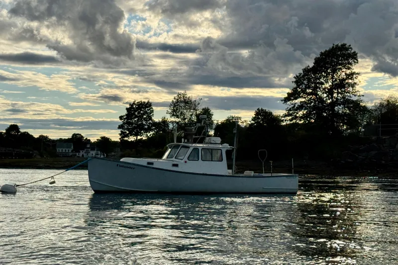 Slide: The Image of 2007 Northern Bay 36 boat anchored on calm water at sunset. - 2