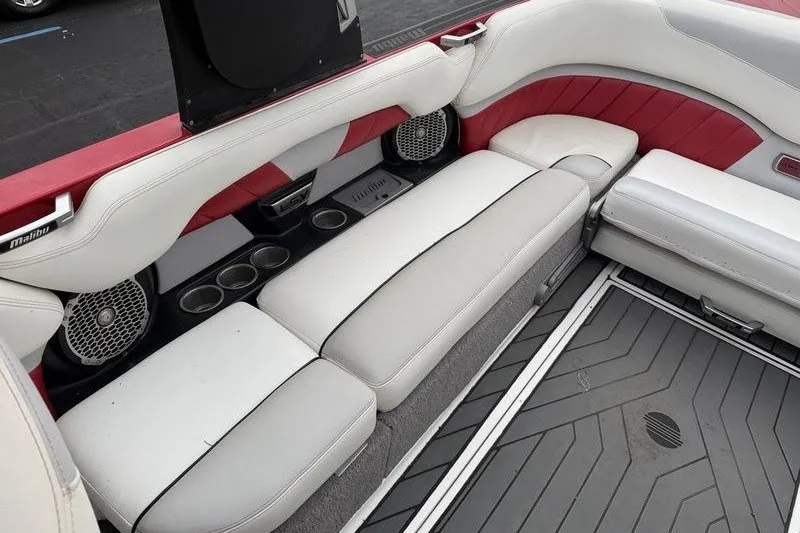 Slide: The Image of 2016 Malibu Wakesetter 25 LSV interior with white and red seating, cup holders, and speakers. - 4