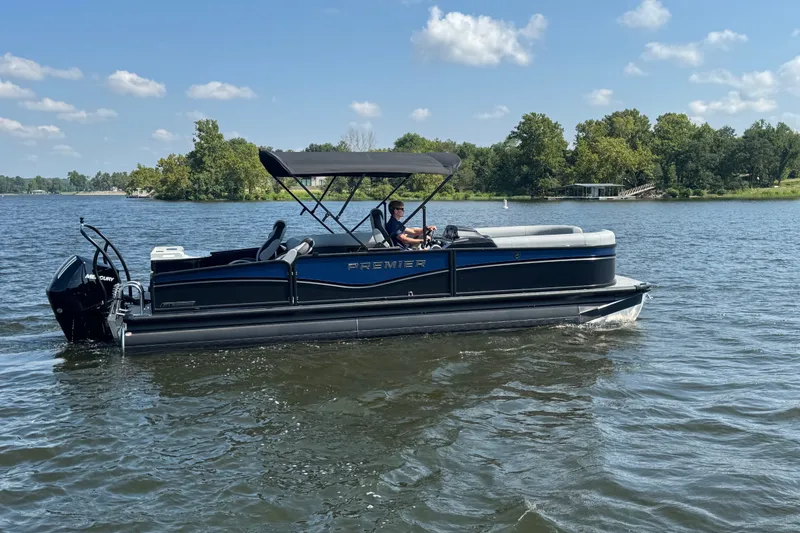 The Image of 2027 Premier 250 Sunsation pontoon boat cruising on a scenic lake. - 1