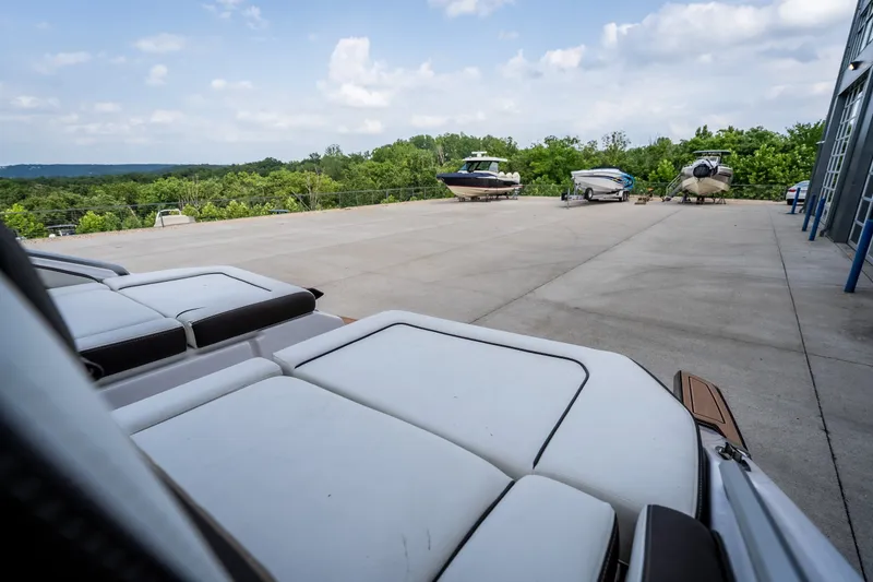 Slide: The Image of 2023 Yamaha Boats 275SE on a spacious outdoor lot with scenic background. - 37