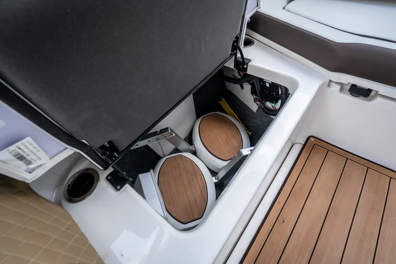 Slide: The Image of 2023 Yamaha Boats 275SE storage compartment with wooden accents and modern design. - 31