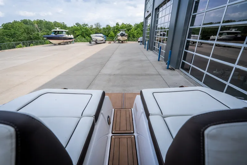 Slide: The Image of 2023 Yamaha Boats 275SE at marina, showcasing sleek design and spacious seating. - 36