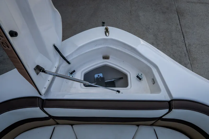 Slide: The Image of Open storage compartment on 2023 Yamaha Boats 275SE, featuring cushioned seating and hydraulic support. - 23