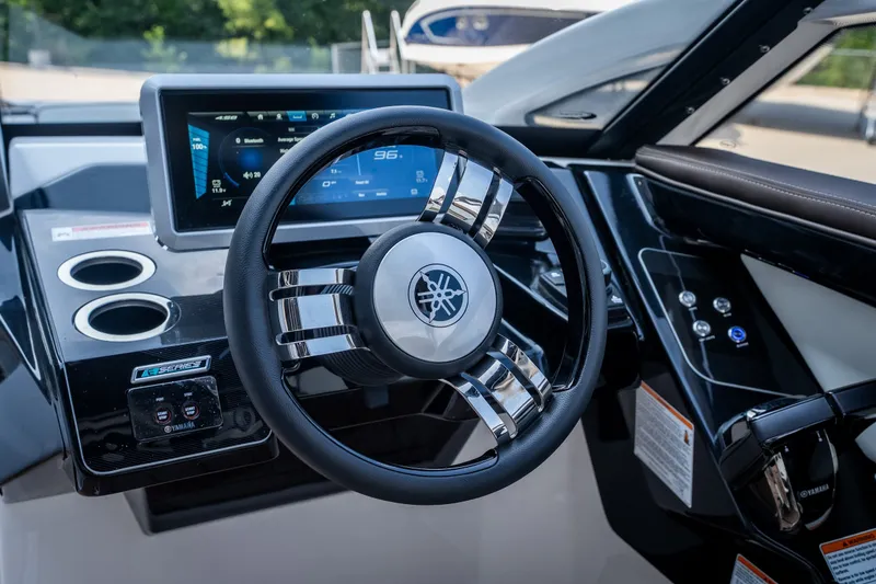 Slide: The Image of 2023 Yamaha Boats 275SE dashboard with modern steering wheel and digital display. - 14