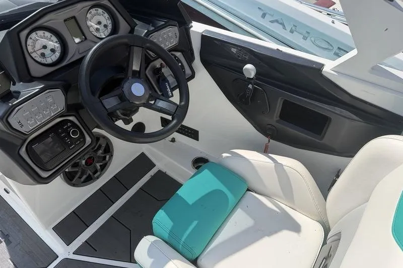 Slide: The Image of 2019 Axis A24 boat cockpit with steering wheel, gauges, and white seating. - 3