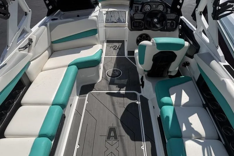 Slide: The Image of 2019 Axis A24 boat interior with teal and white seating, modern dashboard, and spacious layout. - 5