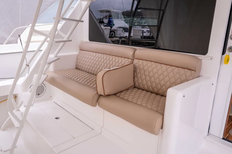 Slide: The Image of Luxury seating on a 2005 Viking 56 Convertible yacht, featuring beige quilted upholstery. - 20