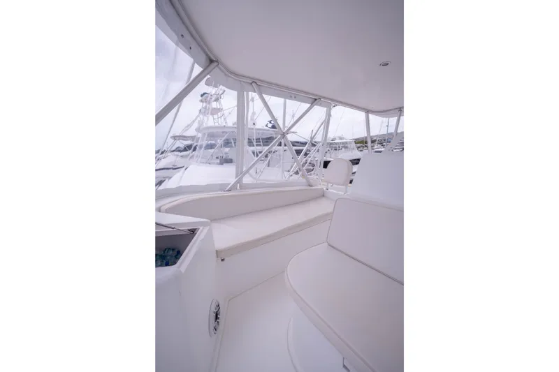 Slide: The Image of Interior view of a 2005 Viking 56 Convertible yacht, featuring white seating and windows. - 27